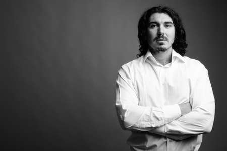 Handsome businessman with mustache against gray backgroundの写真素材