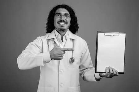 Handsome man doctor with mustache against gray backgroundの写真素材