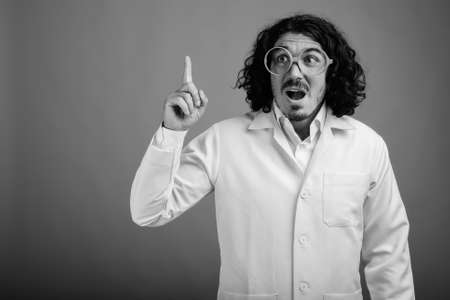 Handsome man doctor with mustache wearing eyeglasses against gray backgroundの写真素材