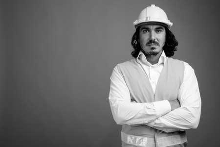 Handsome man construction worker with mustache against gray backgroundの写真素材