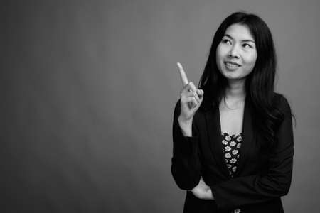 Portrait of happy Asian woman wearing dress and cardigan sweaterの写真素材