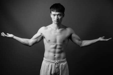Portrait of young muscular Chinese man shirtlessの写真素材