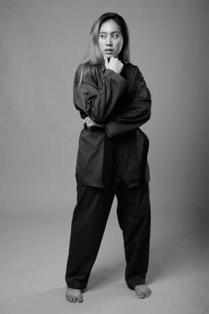Portrait of young Asian woman wearing karate Gi ready to fightの写真素材