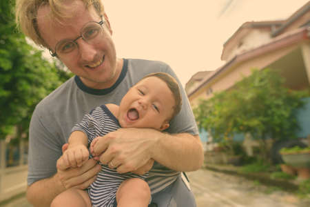 Father and baby son bonding together at home outdoorsの写真素材