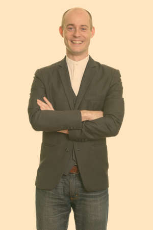 Happy bald Caucasian businessman smiling with arms crossedの写真素材