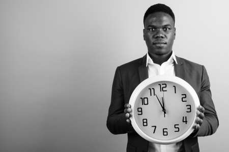 Young African businessman wearing suit against white backgroundの写真素材