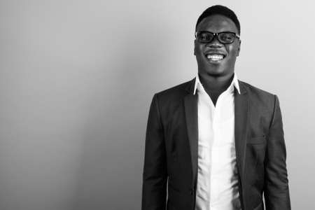 Happy young African businessman wearing suit against white backgroundの写真素材