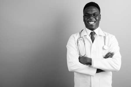Happy young African man doctor against white backgroundの写真素材