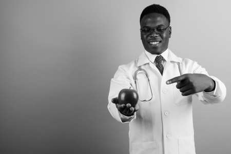Happy young African man doctor against white backgroundの写真素材