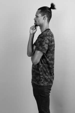Young bearded handsome African man against gray backgroundの写真素材