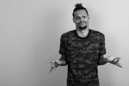 Young bearded handsome African man against gray backgroundの写真素材