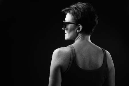 Mature beautiful woman with short hair against black backgroundの写真素材
