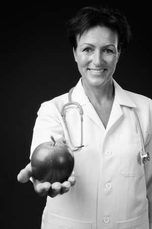 Portrait of happy mature beautiful woman doctor with short hairの写真素材