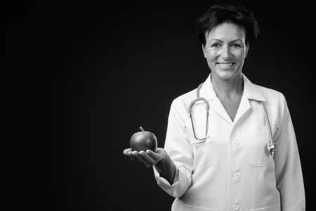 Portrait of happy mature beautiful woman doctor with short hairの写真素材