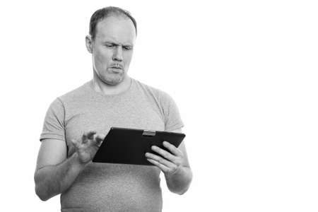 Studio shot of serious mature man using digital tabletの写真素材
