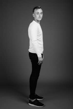 Young handsome man with blond hair against brown backgroundの写真素材