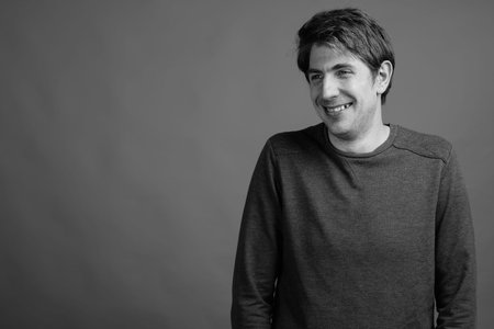 Portrait of happy handsome man against gray background