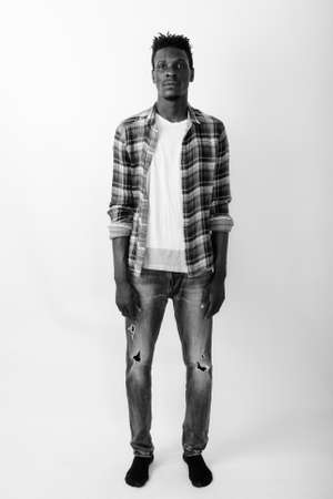 Full body shot of young black African man standing against white backgroundの写真素材