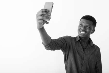 Portrait of happy young African man taking selfieの写真素材