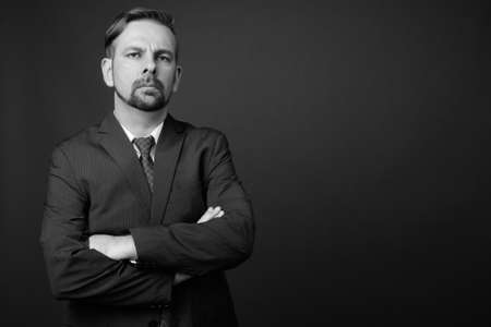 Blond bearded businessman with goatee against gray backgroundの写真素材