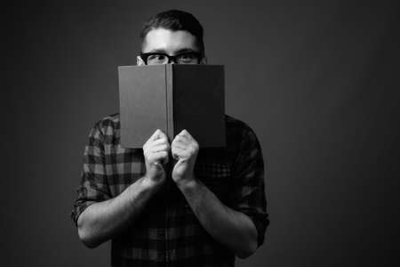 Portrait of young handsome hipster man against gray backgroundの写真素材