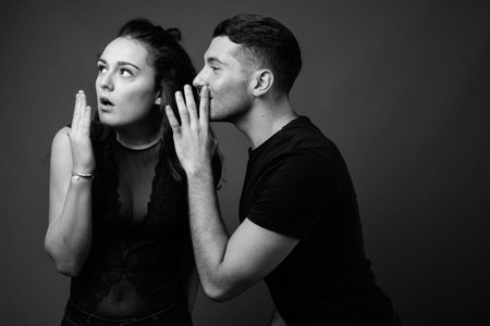 Young couple together and in love against gray background