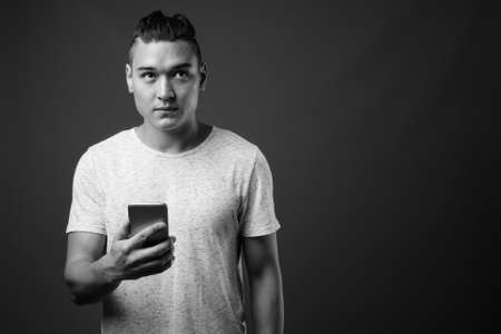 Young handsome multi ethnic man against gray backgroundの写真素材