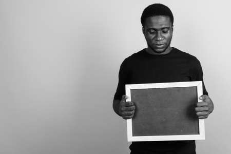Young African man wearing black shirt against gray backgroundの写真素材