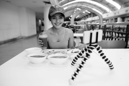 Young beautiful Asian tourist woman enjoying Indian cuisine at the restaurant