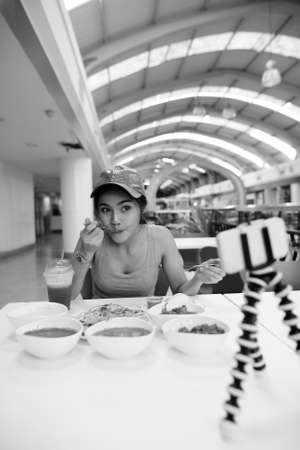 Young beautiful Asian tourist woman enjoying Indian cuisine at the restaurantの写真素材
