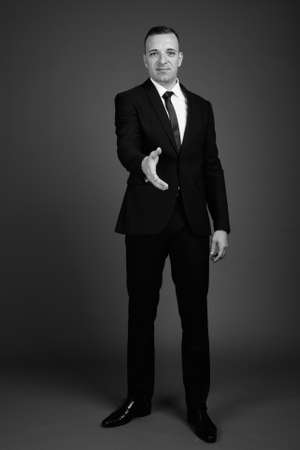 Businessman wearing suit against gray backgroundの写真素材