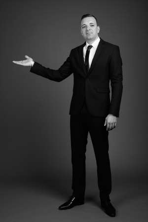 Businessman wearing suit against gray backgroundの写真素材