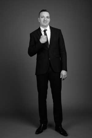 Businessman wearing suit against gray backgroundの写真素材