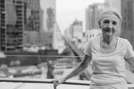 Beautiful senior woman with blond hair against view of the cityの写真素材