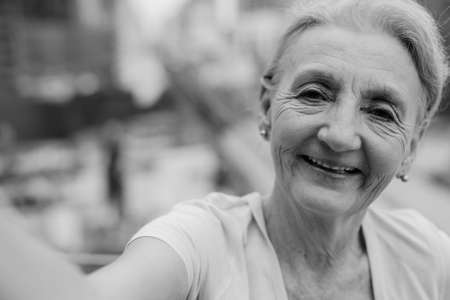 Beautiful senior woman with blond hair against view of the cityの写真素材