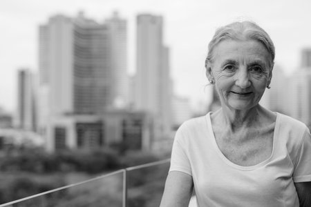 Beautiful senior woman with blond hair against view of the city