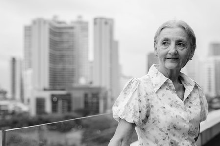 Beautiful senior woman with blond hair against view of the city