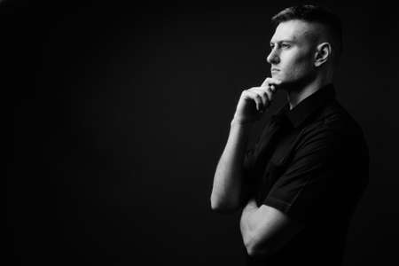 Portrait of young handsome businessman against gray backgroundの写真素材