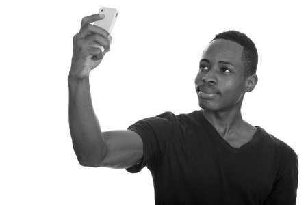 Young African man taking selfie with mobile phoneの写真素材