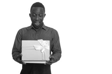 Young happy African man smiling and opening gift boxの写真素材