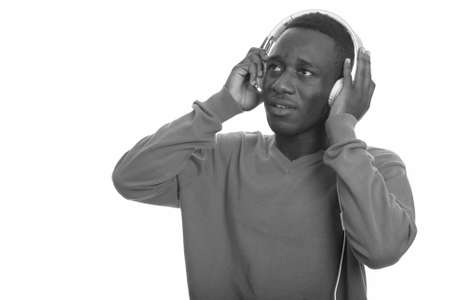 Young African man listening to music while thinkingの写真素材