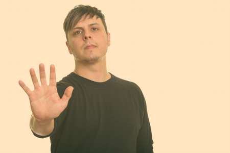 Studio shot of Caucasian man with stop hand gesture