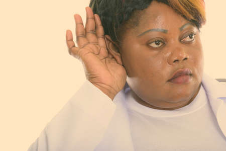 Close up of fat black African woman doctor listening while thinkingの写真素材