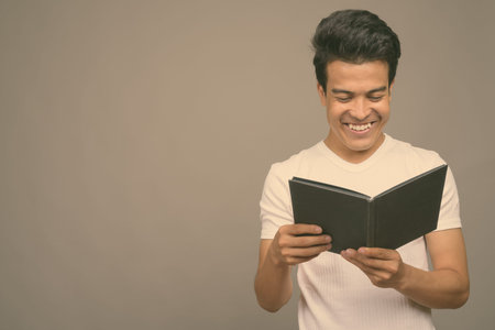 Portrait of young Asian man against gray background