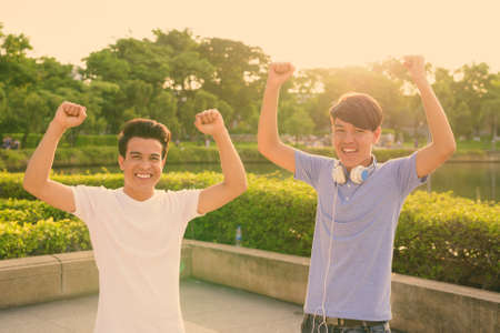Young Asian man and young Asian teenage boy at the park togetherの写真素材