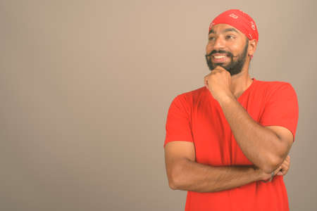 Young handsome Indian man against gray backgroundの写真素材