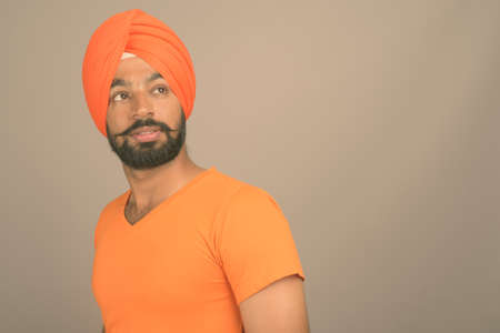 Young handsome Indian Sikh man wearing turban against gray backgroundの写真素材