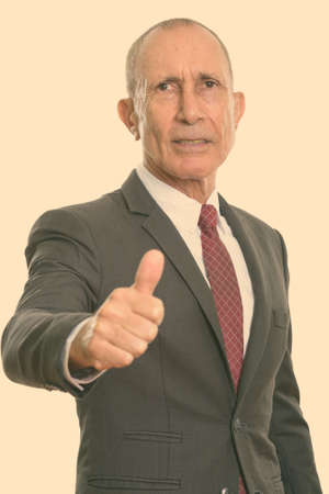 Studio shot of senior businessman giving thumb upの写真素材