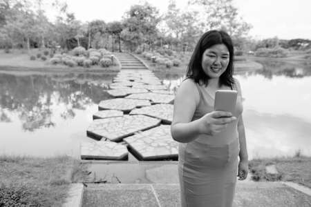 Beautiful overweight Asian woman relaxing at the park in the cityの写真素材