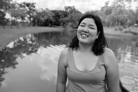 Beautiful overweight Asian woman relaxing at the park in the cityの写真素材